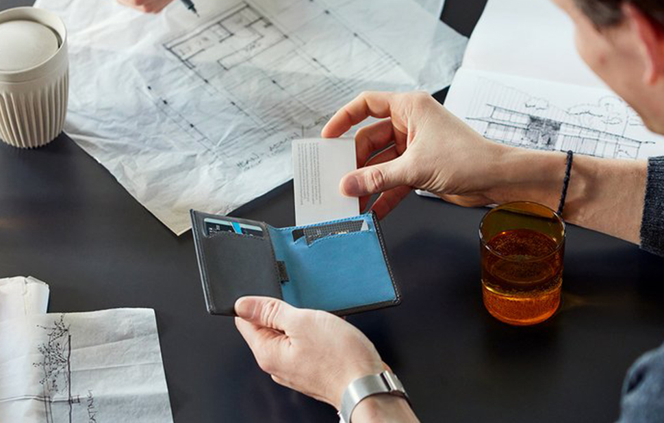 男性がNote Sleeve Walletからカードを取り出すイメージ。