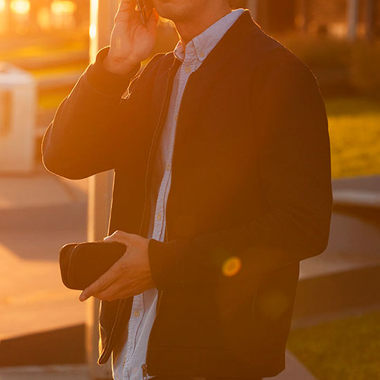 男性がフォンポケットプラスからスマートホンを取り出して誰かと電話しているイメージ