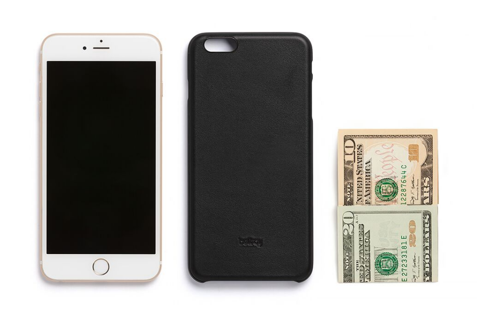 iPhoneの隣に並べたフォンケースブラックの正面画像と折り畳んだ紙幣2枚の写真
