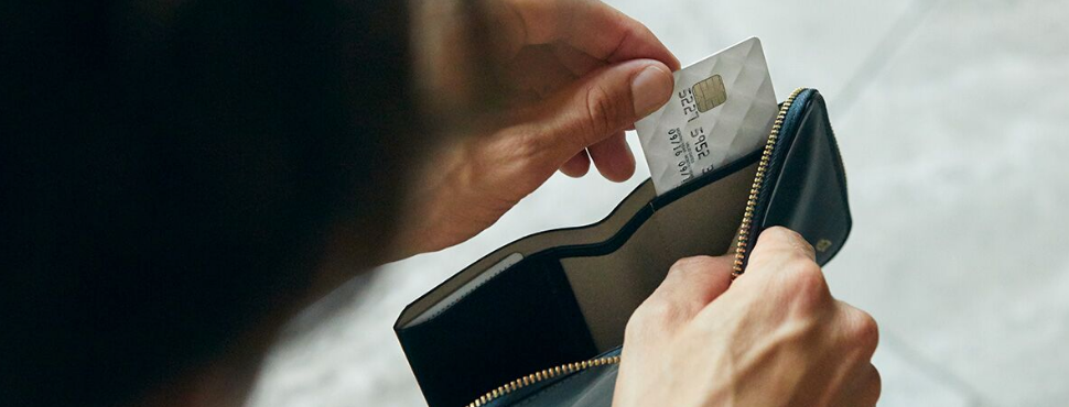 Bellroy Zip Wallet Designers Edition Blackのインナースロットからカードを取り出している男性のイメージ