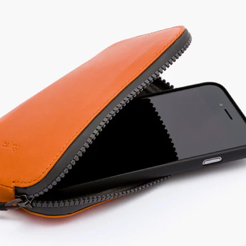 オールコンディションズフォンポケットバーントオレンジにスマートフォンを収納している写真